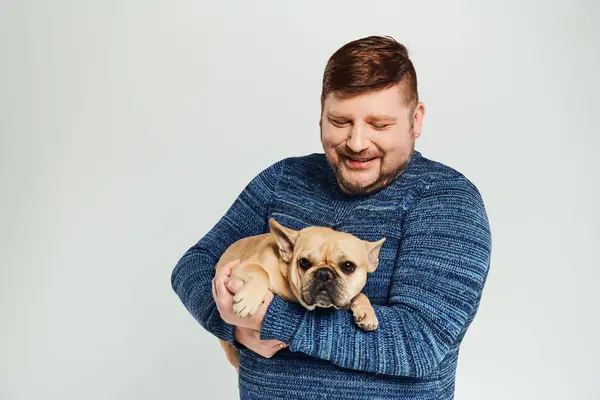A man cradling a small dog tenderly in his arms. — Stock Photo