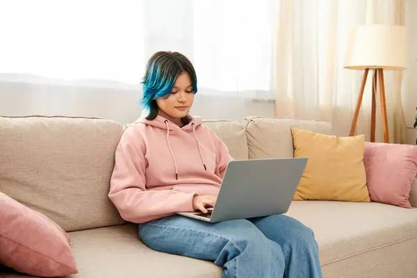 Teenie-Mädchen mit blauen Haaren sitzt mit Laptop auf Couch. — Stockfoto