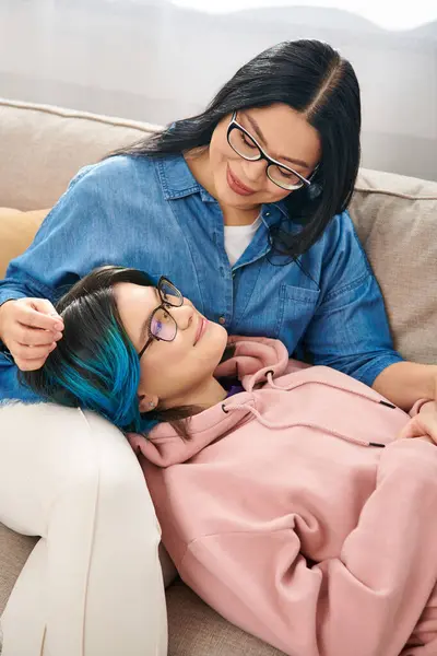 Азіатська мати і підліток дочка ділиться затишним моментом на дивані — стокове фото