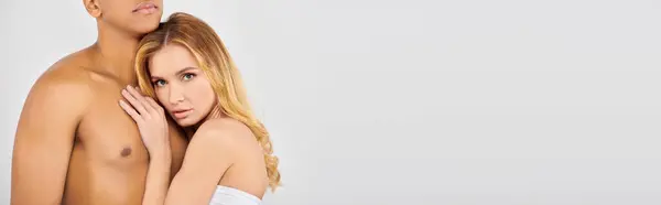 Chic man and woman pose together on white backdrop. — Stock Photo