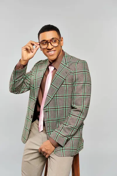 A fashionable man in a plaid blazer posing confidently. — Stock Photo