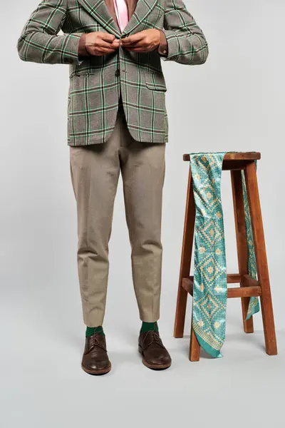 Stylish man in blazer and tie gracefully standing on a stool. — Stock Photo