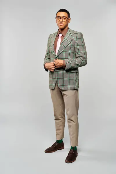 A man in a green blazer and green pants poses confidently. — Stock Photo