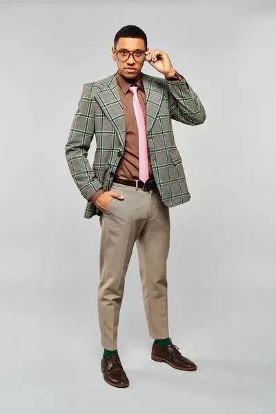 Uomo elegante posa con fiducia in un blazer verde alla moda e una cravatta rosa. — Foto stock