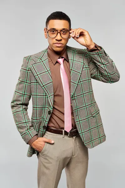 Un uomo alla moda posa con fiducia in un elegante blazer a quadri. — Foto stock