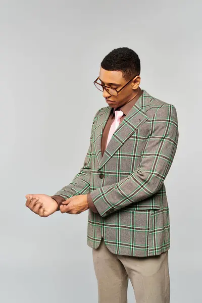 Stilvoller Mann posiert selbstbewusst im grün-braun karierten Blazer. — Stockfoto