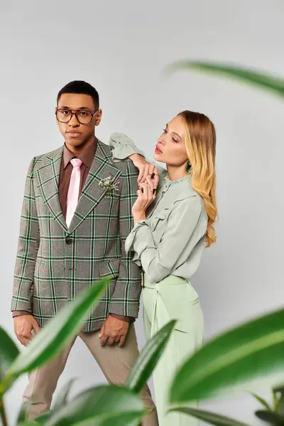 Homem e mulher romanticamente posar na frente de uma planta verde vibrante. — Fotografia de Stock