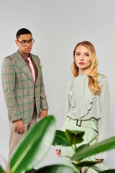 Man and woman pose gracefully in front of plant. — Stock Photo