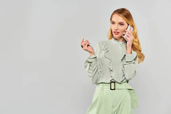 A young woman in a green blouse chats on the telephone. — Stock Photo