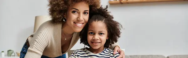 Feliz madre e hija afroamericanas posando para una foto juntas, mostrando amor y unión en casa. - foto de stock