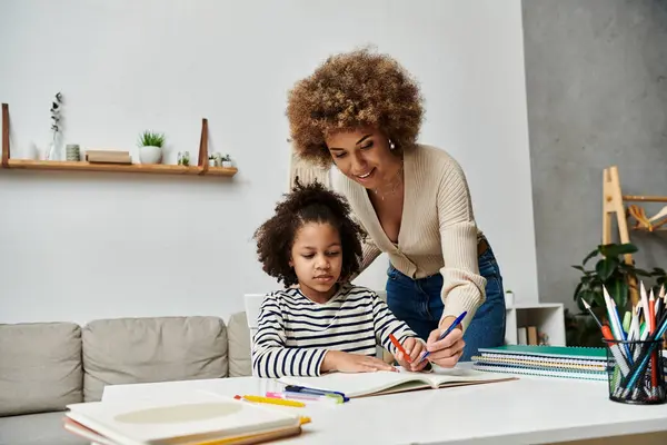 An African-American mother lovingly helps her daughter with homework, creating a bond and fostering learning. — Stock Photo