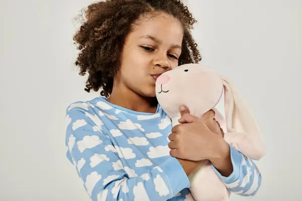 Молодая девушка в пижаме нежно обнимает плюшевое животное — стоковое фото