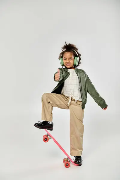 Stylish African American girl skateboarder gliding wearing headphones. — Stock Photo