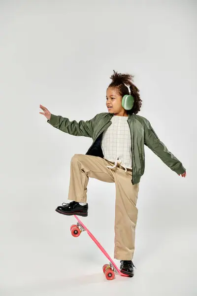 Ein junges Mädchen mit Kopfhörern fährt Skateboard. — Stockfoto