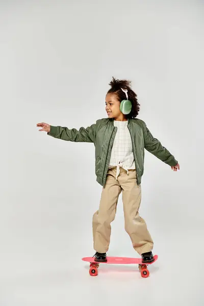 A young girl joyfully skateboarding on a white background, embodying freedom and fun in motion. — Stock Photo