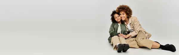 A woman and a man in stylish attire sit on the ground, engaged in conversation, showcasing companionship and connection. — Stock Photo