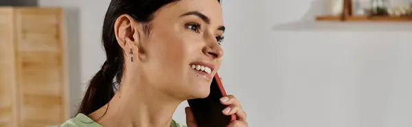 A woman in casual attire talking cheerfully by phone. — Stock Photo