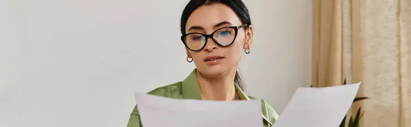 Woman wearing glasses holds a sheet of paper. — Stock Photo