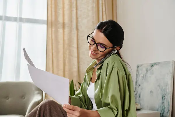A woman sitting on a couch, deep in thought while reading a piece of paper. — Stock Photo
