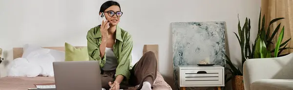 Woman in casual attire using laptop on bed. — Stock Photo