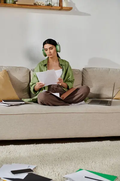 Woman lounging on couch, enjoying music with headphones on. — Stock Photo
