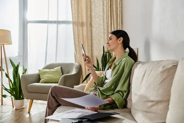 Woman engrossed in cellphone while lounging on couch. — Stock Photo