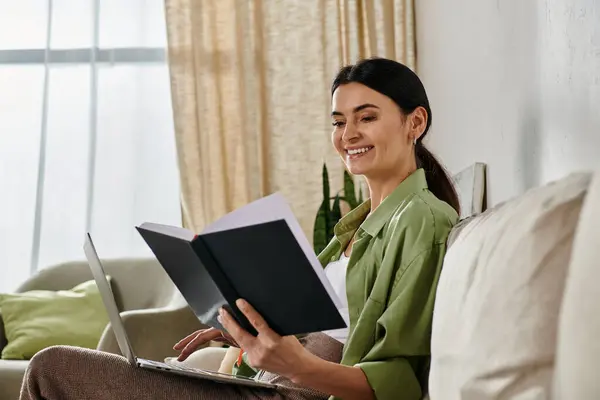 A woman engrossed in a book while seated on a cozy couch. — Stock Photo