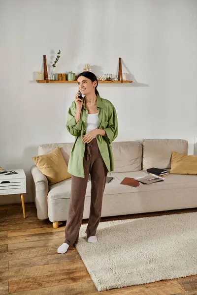 Woman in casual attire talks on cell phone in cozy living room. — Stock Photo