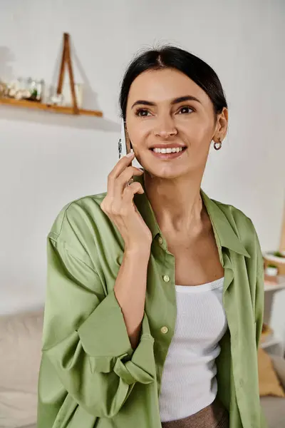 A woman in a green jacket talking on a cell phone. — Stock Photo