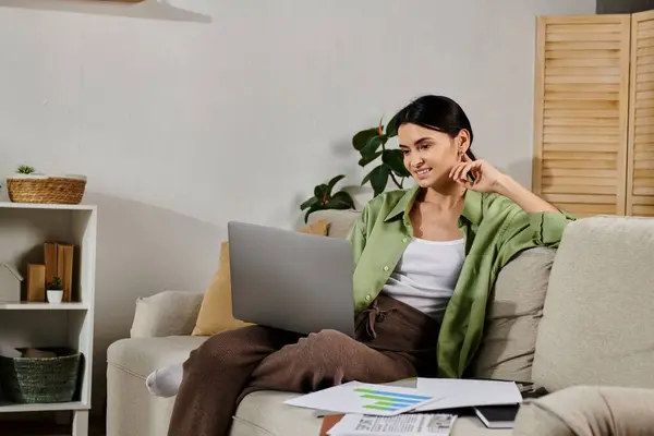 Woman in casual attire engaged with laptop on couch. — Stock Photo