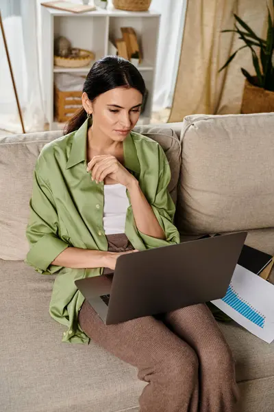 Lässige Frau auf einem Sofa, vertieft in Laptop-Arbeit. — Stockfoto