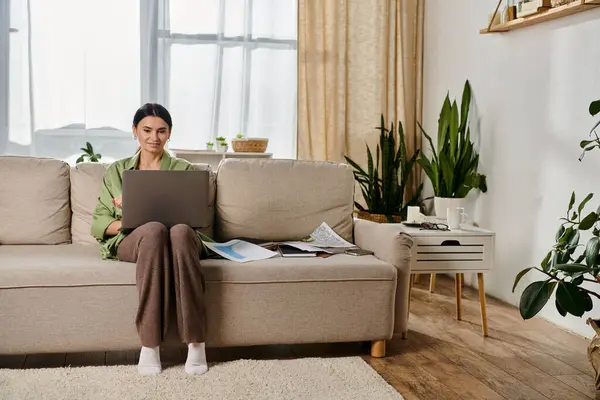 Casual woman working remotely on laptop from cozy couch. — Stock Photo