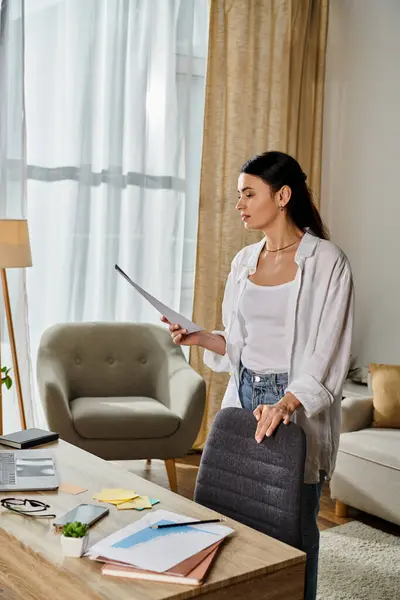 Woman in living room holds papers. — Stock Photo