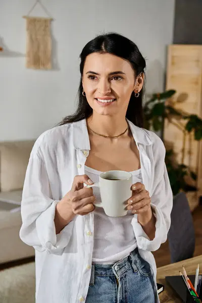 A woman joyfully clasps a steaming cup of coffee — Stock Photo