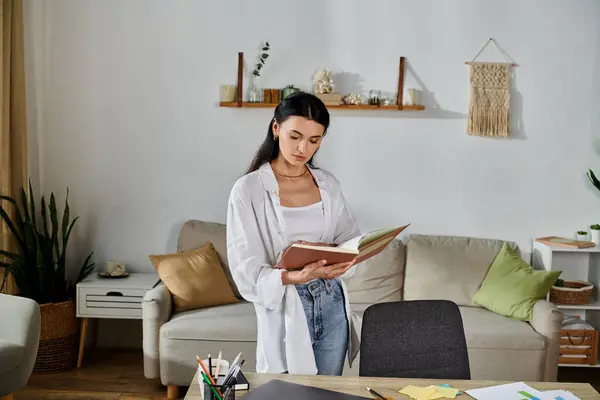 Woman in living room, absorbed in book. — Stock Photo