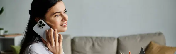 Woman in casual attire talking on cellphone while sitting on couch. — Stock Photo