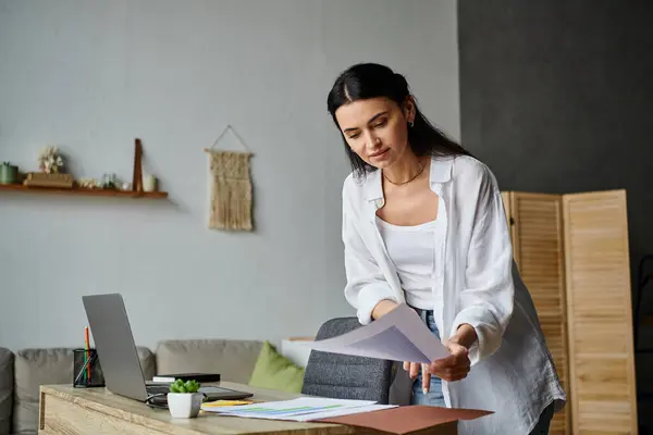 Uma mulher de traje casual em pé na frente de um computador portátil. — Fotografia de Stock