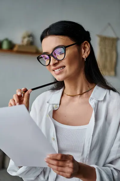 A woman in glasses writing on paper with a pen. — Stock Photo