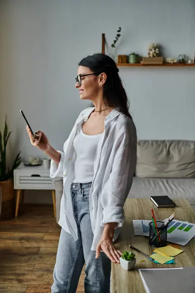Woman in casual attire using smartphone in trendy living space. — Stock Photo