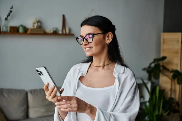 Woman with glasses focused on cell phone screen. — Stock Photo