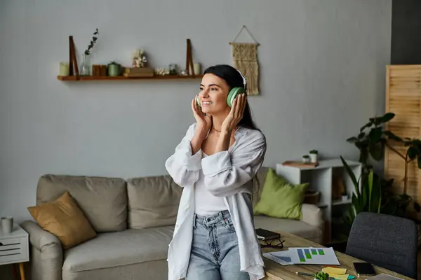 A woman in casual attire listening music in a stylish living room. — Stock Photo