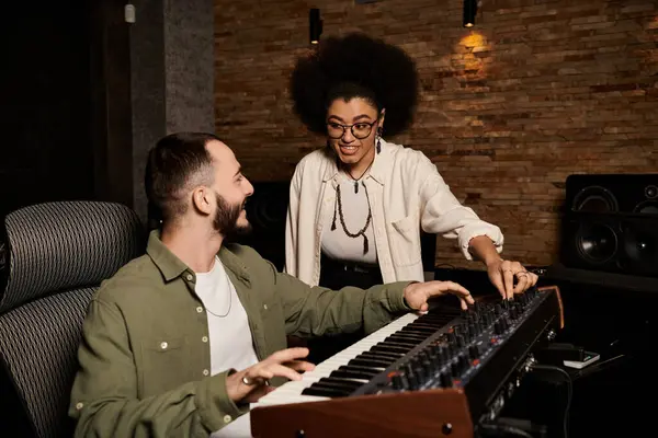 A man and a woman collaborate in a recording studio, immersed in creating music for their band rehearsal. — Stock Photo