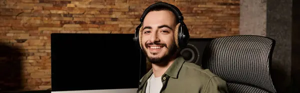 Un musicien en casque sourit à son ordinateur lors d'une répétition dans un studio d'enregistrement. — Photo de stock