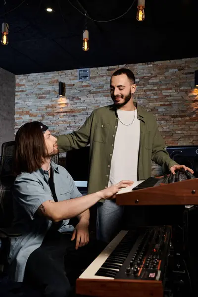 Two talented musicians stand in a recording studio, collaborating on music for their bands next project. — Stock Photo
