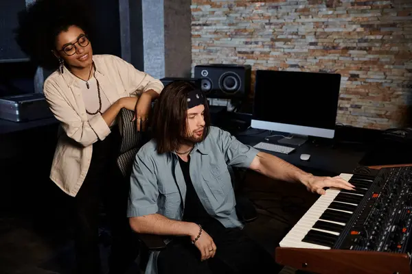 Un homme et une femme collaborent à la musique dans un studio d'enregistrement pendant qu'ils répètent pour leur groupe. — Photo de stock