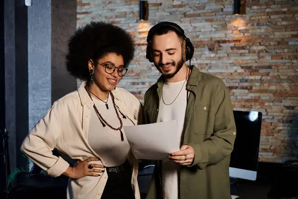 A man and woman are collaborating in a recording studio for a music band rehearsal, surrounded by musical instruments and equipment. — Stock Photo