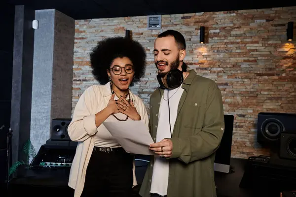 A man and a woman collaborate in a recording studio, immersed in music band rehearsal. — Stock Photo