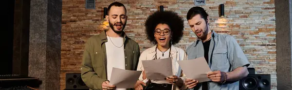 Un groupe de musique répète, tenant des papiers devant un mur de briques dans un studio d'enregistrement. — Photo de stock