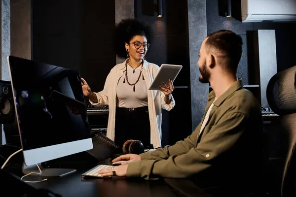 Ein Mann und eine Frau arbeiten in einem professionellen Tonstudio zusammen, um Musik für den bevorstehenden Auftritt ihrer Bands einzustudieren. — Stockfoto