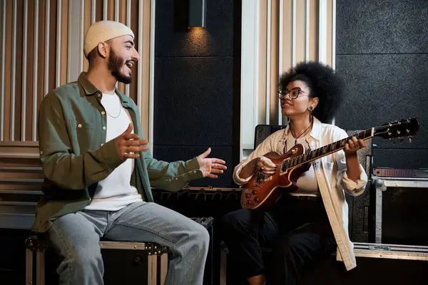 A man and woman passionately play guitars in a recording studio, creating captivating music together. — Stock Photo